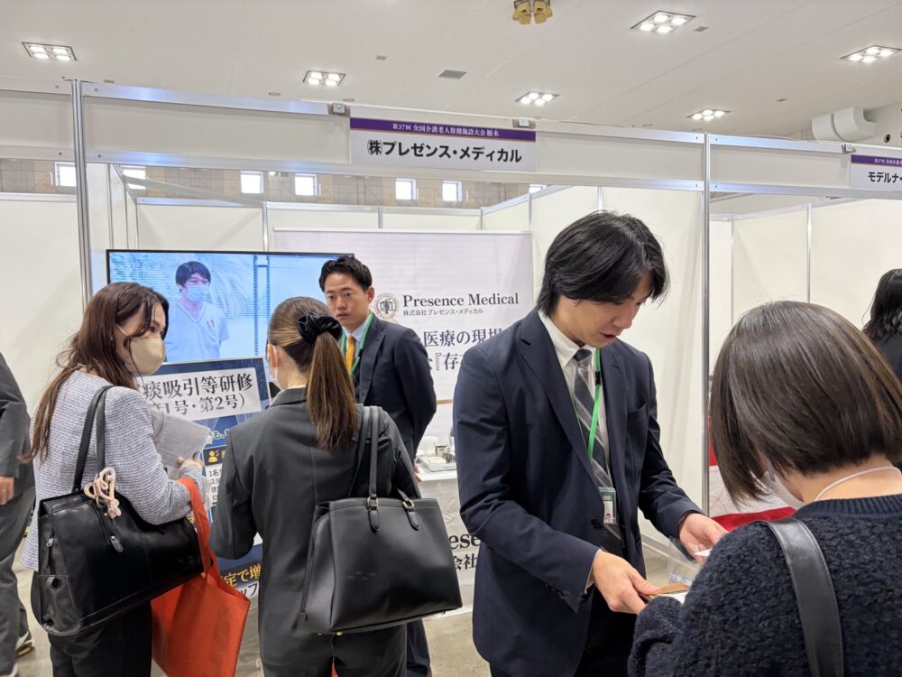 プレゼンス・メディカルのブースでご来場の方にご案内している様子
