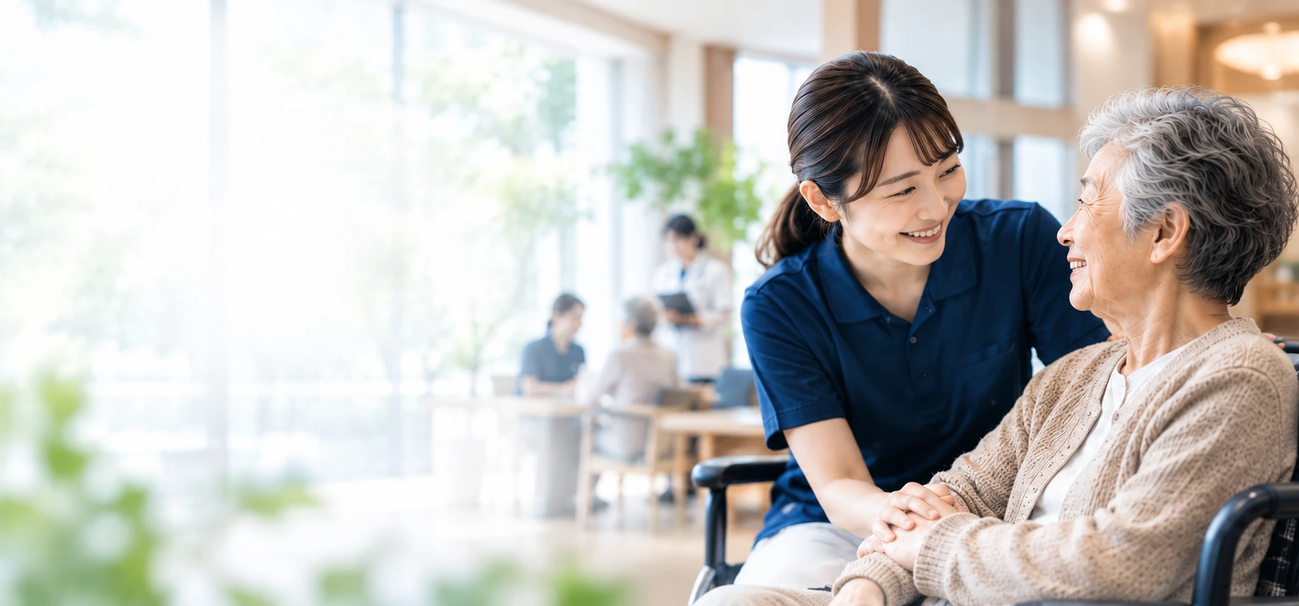 介護職員が利用者様の手を取り、笑顔で話しかけている様子